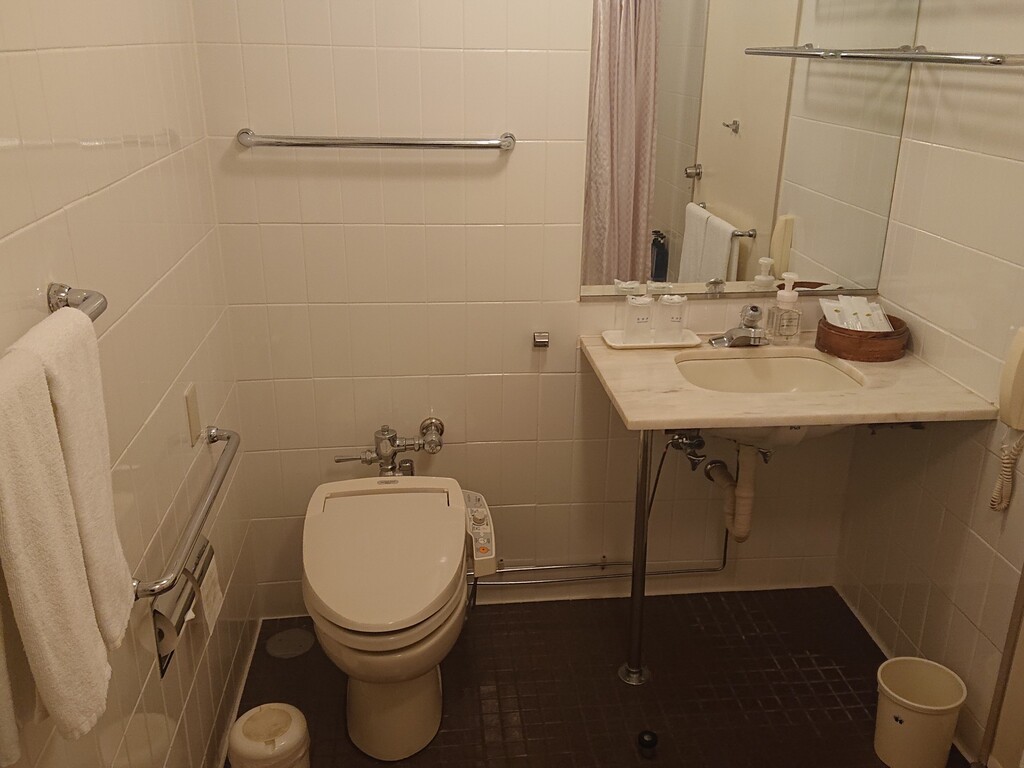【スタンダードダブル・洗面所】トイレ横に手すり、洗面台の下に車いす用のスペースを設けております。